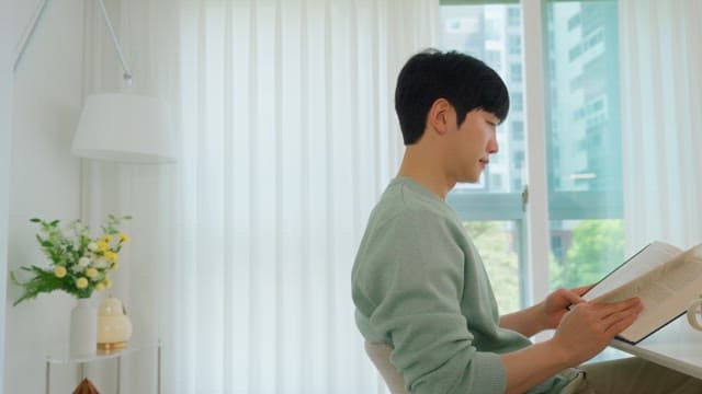 Man Reading a Book While Drinking Coffee