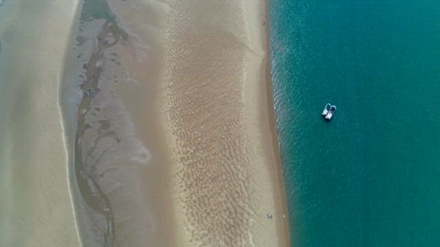 Ocean coastline with a sandy beach and a boat
