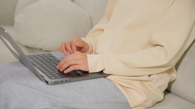 Woman using a laptop on a sofa