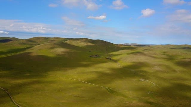 Expansive green hills under a blue sky