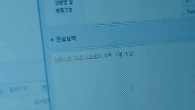 Close-up of computer screen with medical information and hands typing