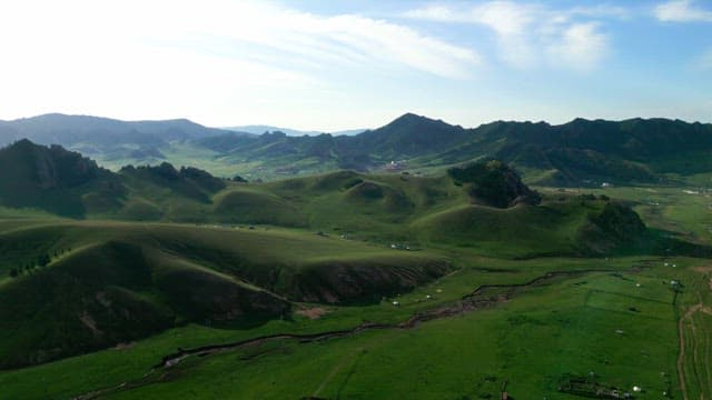 Expansive green hills and distant mountains