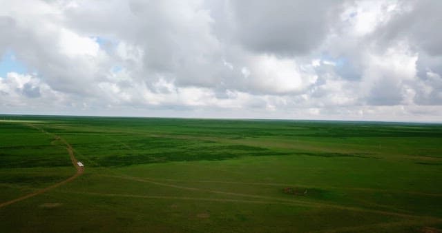 Large green fields with farm buildings