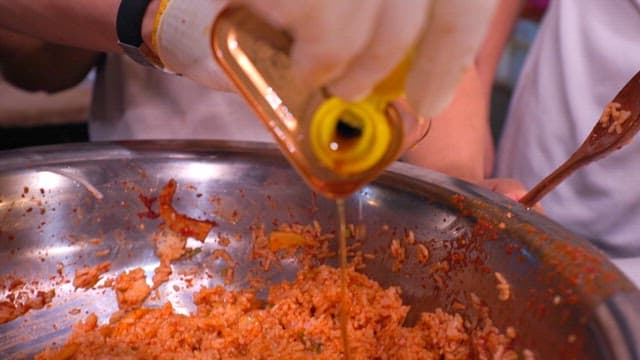 Adding sesame oil to bibimbap with julienne Korean radish salad