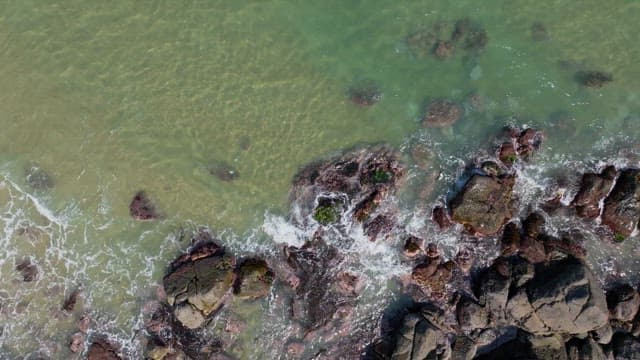 Rocky shoreline with clear waves crashing against the rocks