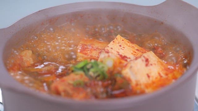 Mustard leaf kimchi stew with tofu boiling in a pot