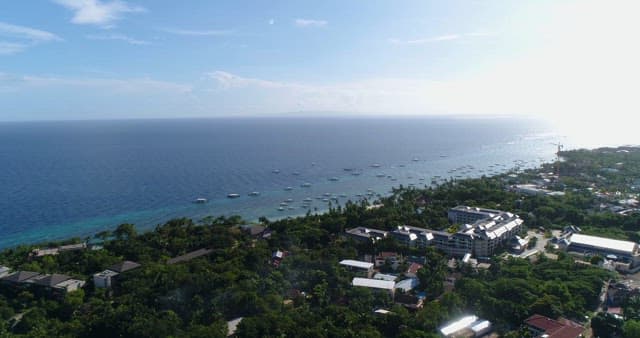Tropical Coastal Village and Bancas Floating on the Sea