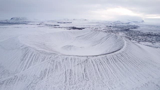 Snow-covered volcanic crater in a vast landscape