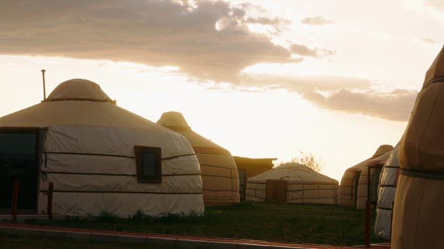 Traditional yurts under a setting sun