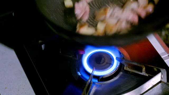 Cooking meat and garlic on a gas stove