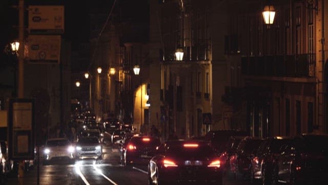 Alley at Night with Cars Lined up Passing by