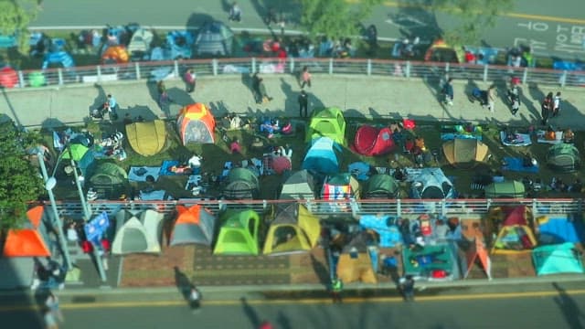 People Pitching Tents on a Pedestrian Road in the City