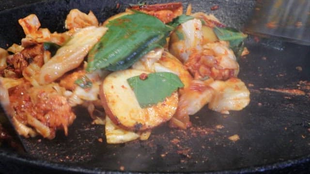 Spicy stir-fried chicken in a hot pan