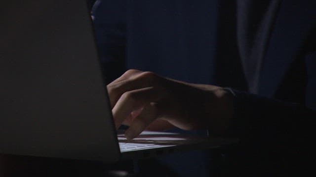 Person Working on Laptop in Dim Light