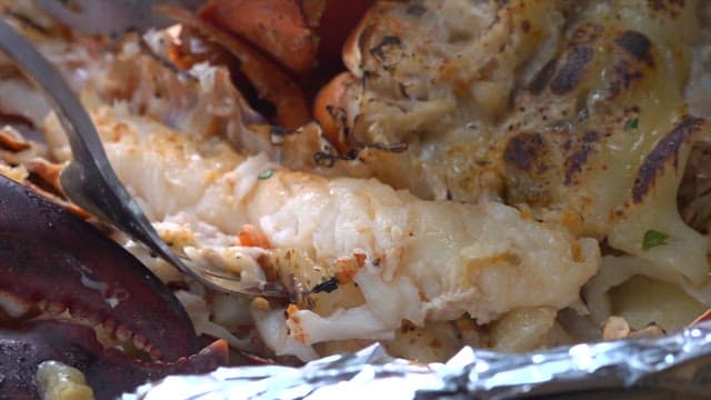Person chopping lobster meat with a fork
