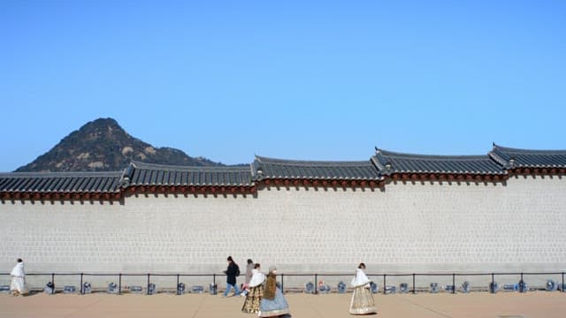 Tourists Passing by the Wall of Traditional Korean palace