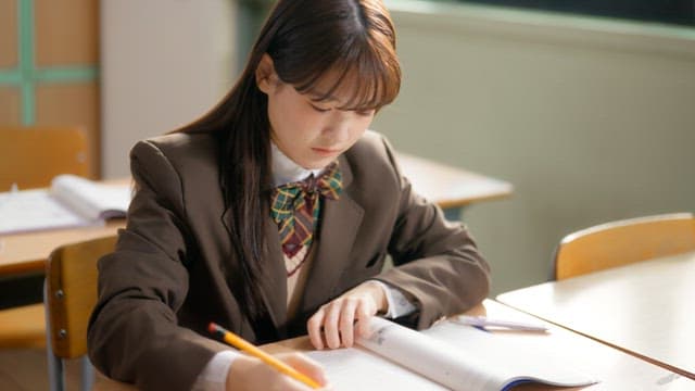 Student sharpening a pencil while studying in the classroom