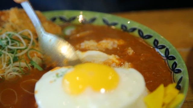 Spoonful of curry rice with a fried egg