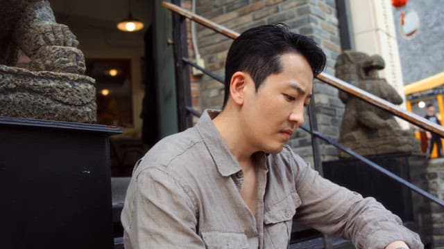 Man sitting on steps outside a building