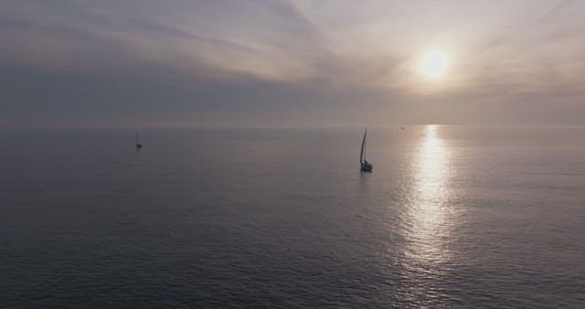 Sailboats on a calm sea at sunset