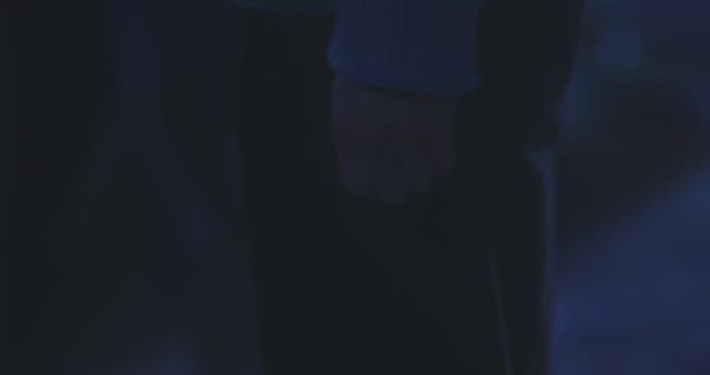 Man standing on the street at night with his fists clenched