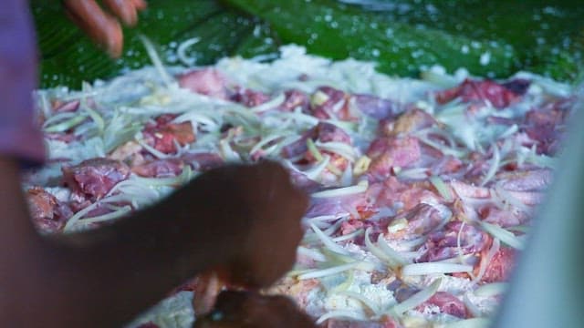 Preparing chicken and onions to make Laplap, a traditional Vanuatu dish