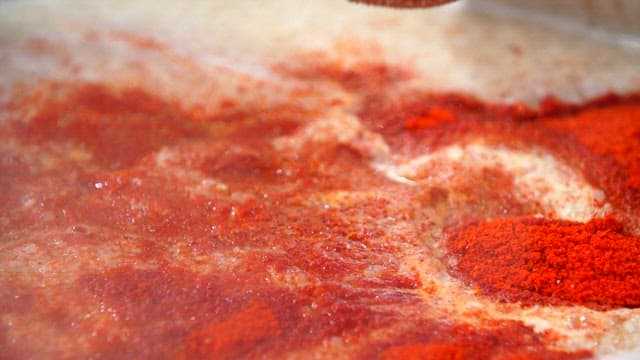 Perilla seeds powder being added to beef leg bone broth