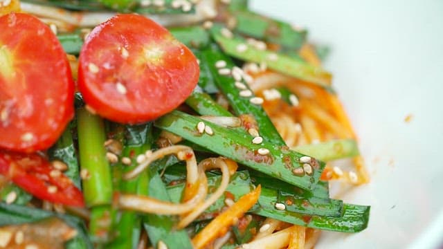 Spicy noodles with tomato, sesame seeds and chives