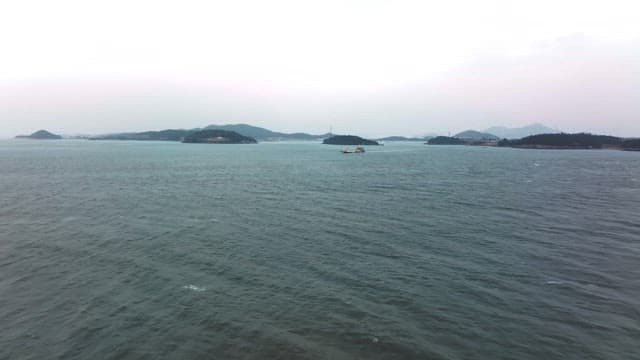 Tranquil Sea with Distant Boat and Islands
