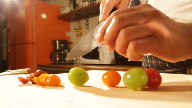 Slicing Fresh Fruit on Cutting Board in Kitchen