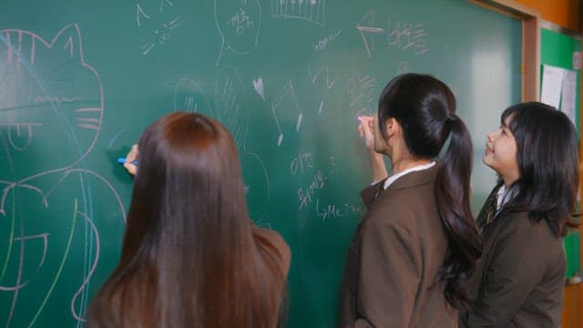 Students scribbling on a classroom blackboard