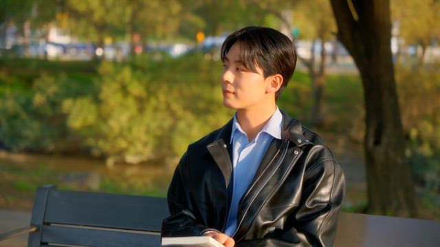 Man reading a book on a park bench