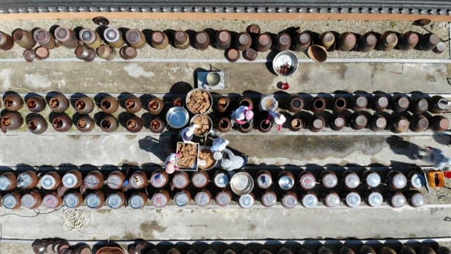 Preparing traditional Korean fermented soybean paste in neatly arranged crocks