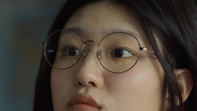 Young woman with glasses looking intently