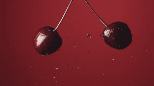 Fresh cherries with water droplets in motion