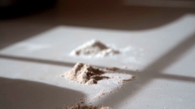 Different piles of flour on a sunlit table indoors