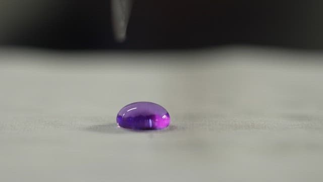 Cutting purple liquid in half with tweezers