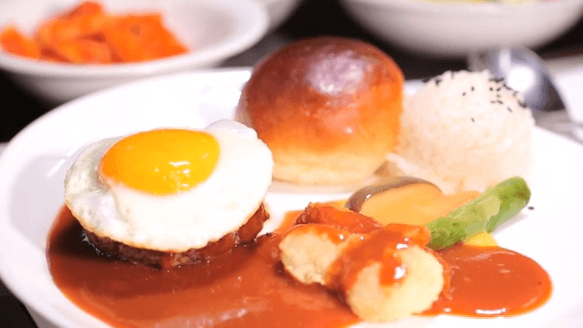 Fried egg and hamburger steak plated on a plate