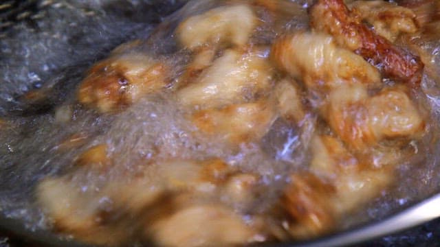 Fried pork being cooked in hot oil