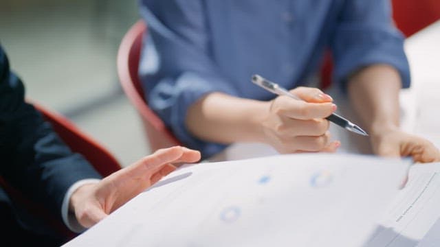 Two colleagues discussing work at a desk