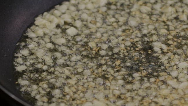 Putting mussels into a frying pan covered in oil