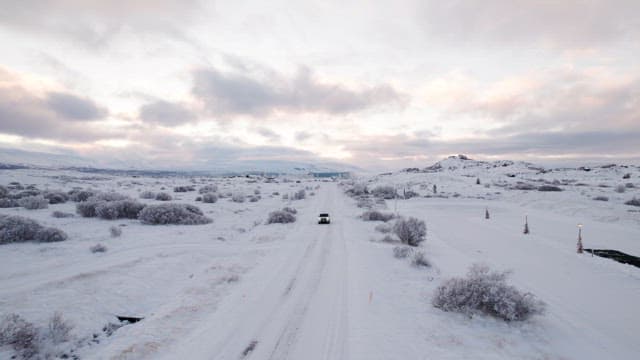 Snowy landscape with a car on a road