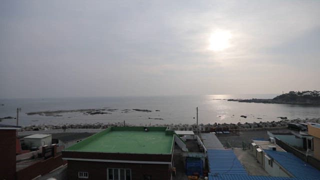 Sunset view over the sea from a coastal town with drying fish on the rooftop