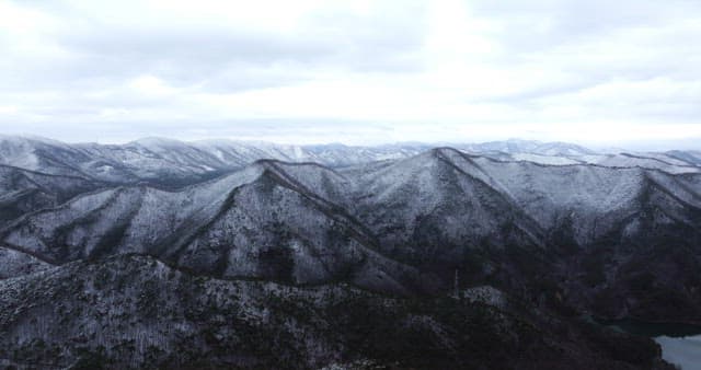 Snow-covered mountains under cloudy skies