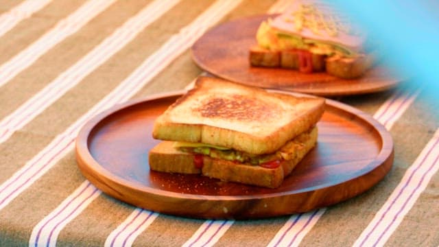 Delicious sandwiches on wooden plates on a striped tablecloth