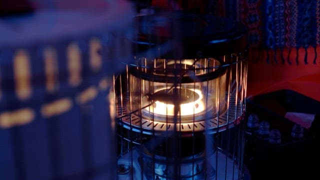 Lit heater brightening up the dark interior of tent