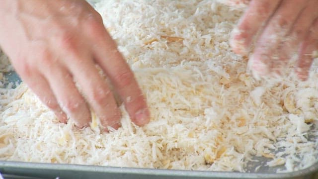 Coating the fish in egg and batter to make fish fritters