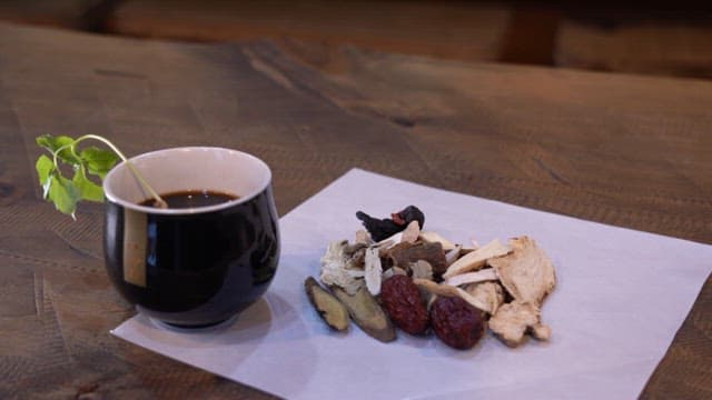 Herbal tea with a cup and medicinal herbs on a wooden table