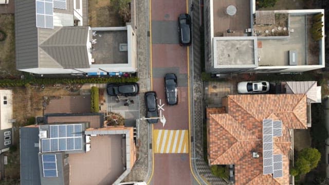 Car passing by on a residential road with parked cars