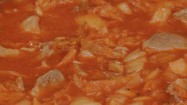 Pot of kimchi stew boiling with flavorful ingredients